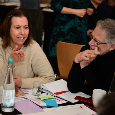 A white woman with short brown hair and a white man wearing glasses discussing civic activity