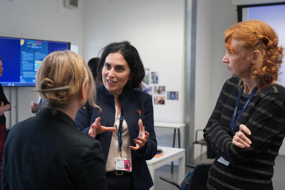 Three people stood up talking to each other