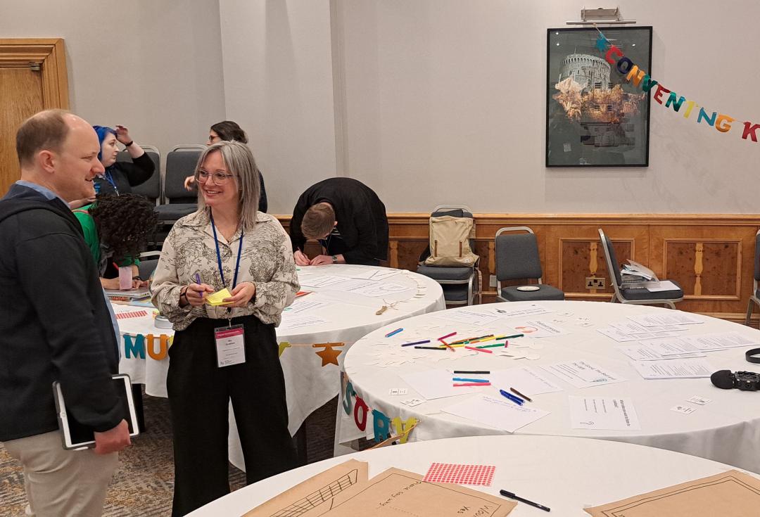 Nic Gratton from The Community Cast talking to delegates at Engage Conference and the Convening Knowledges stall