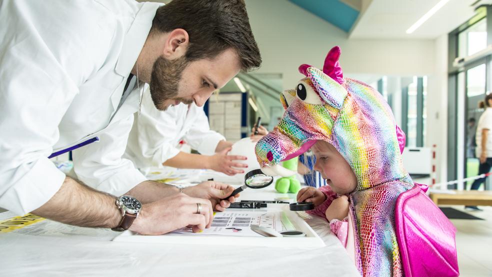 Lancaster University: scientist engaging with children, magnifying glass