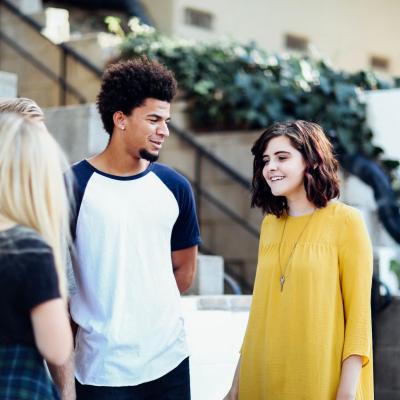 group of young people standing and talking together