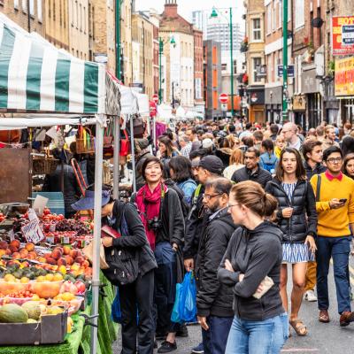 A busy outdoor market with lots of people browsing the stalls