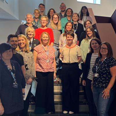 Group of participants from LMJU standing in a group on a set of stairs 