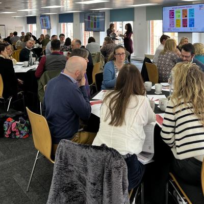 Members of the NCIA action learning groups discussing topics around tables.