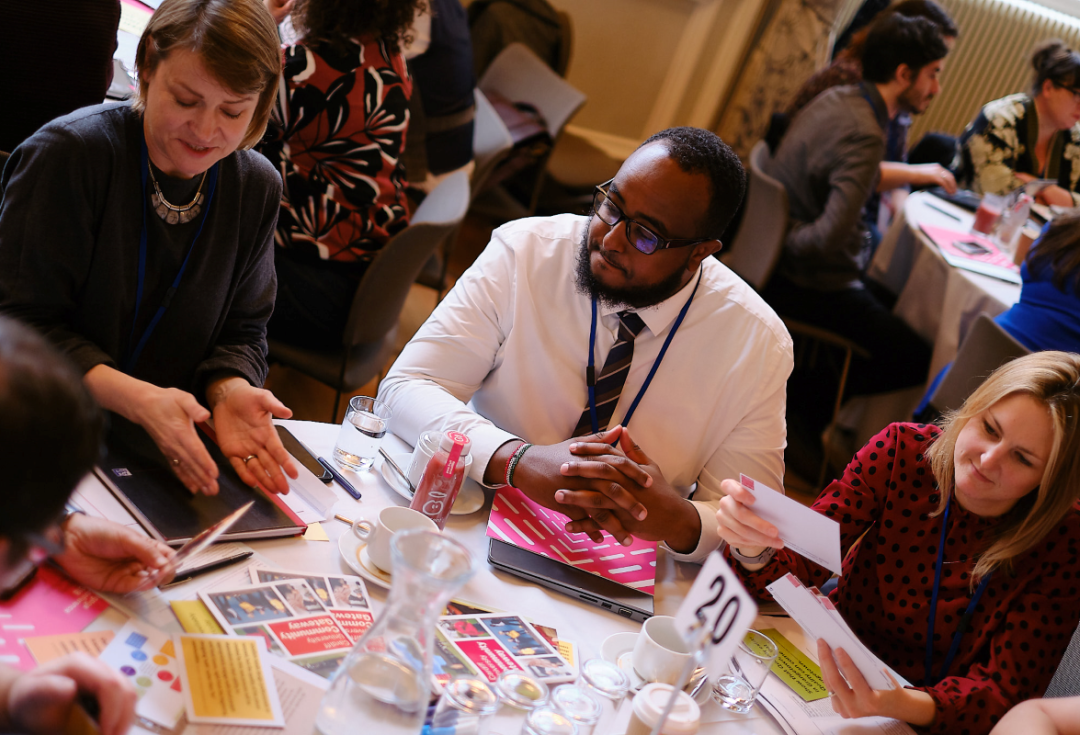A group of people sat at a table with post it notes