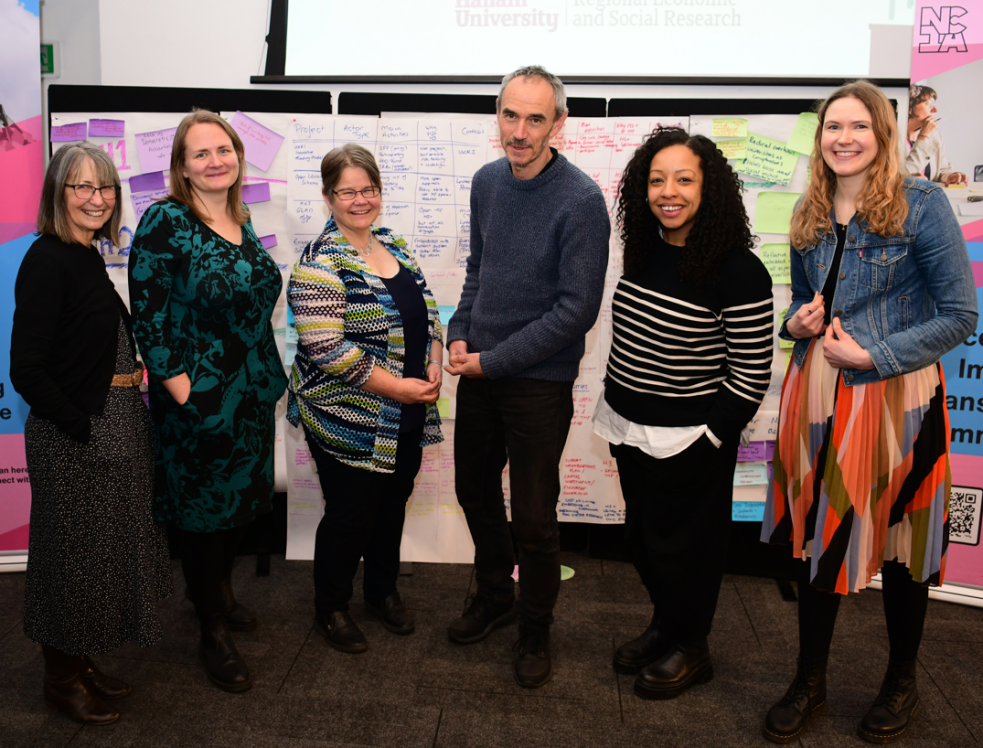 Ann, Zoe, Sophie, Paul, Gemma and Asphodel standing together and smiling at the NCIA action learning event